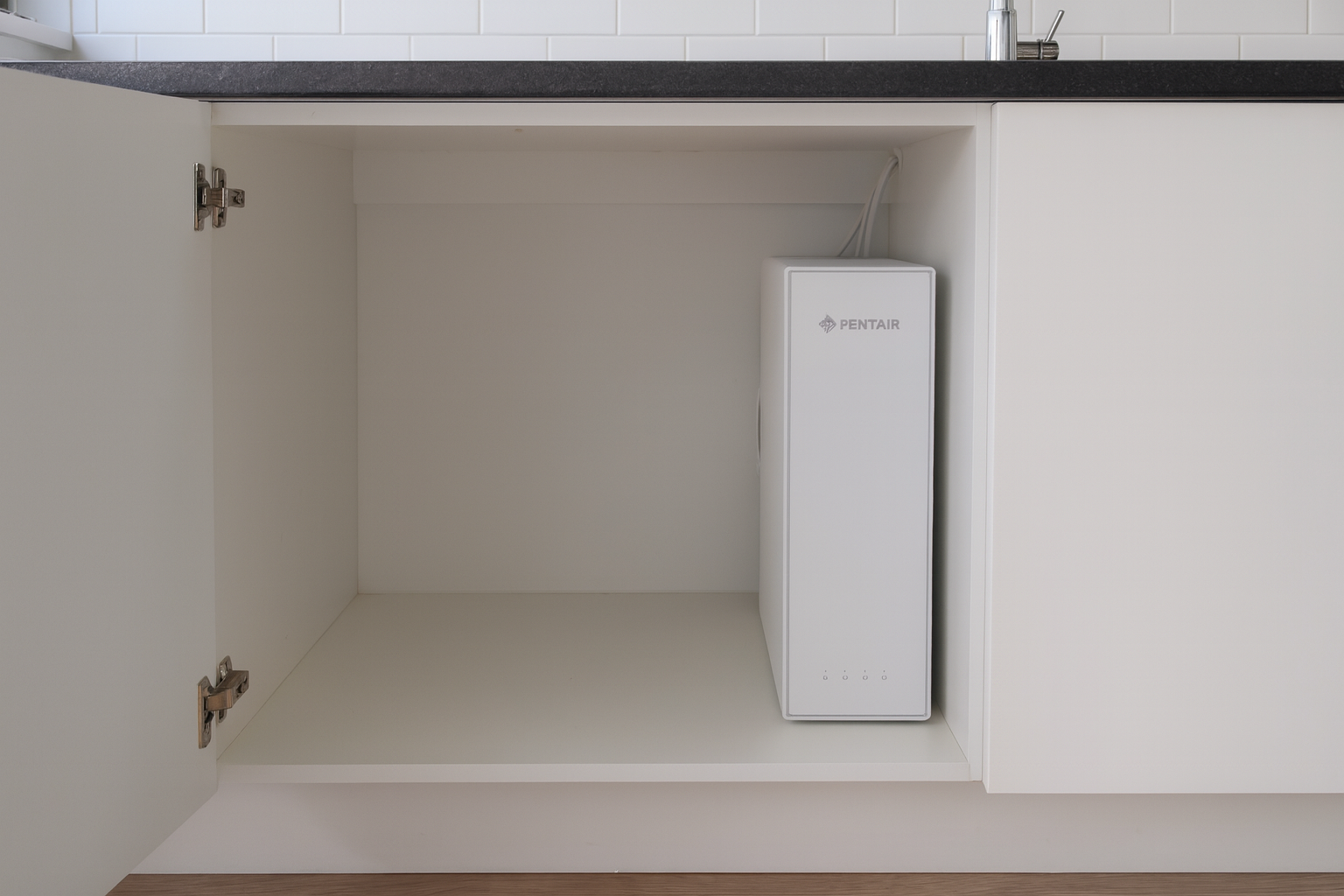 The ES60 being fitted in an under-sink cupboard.
