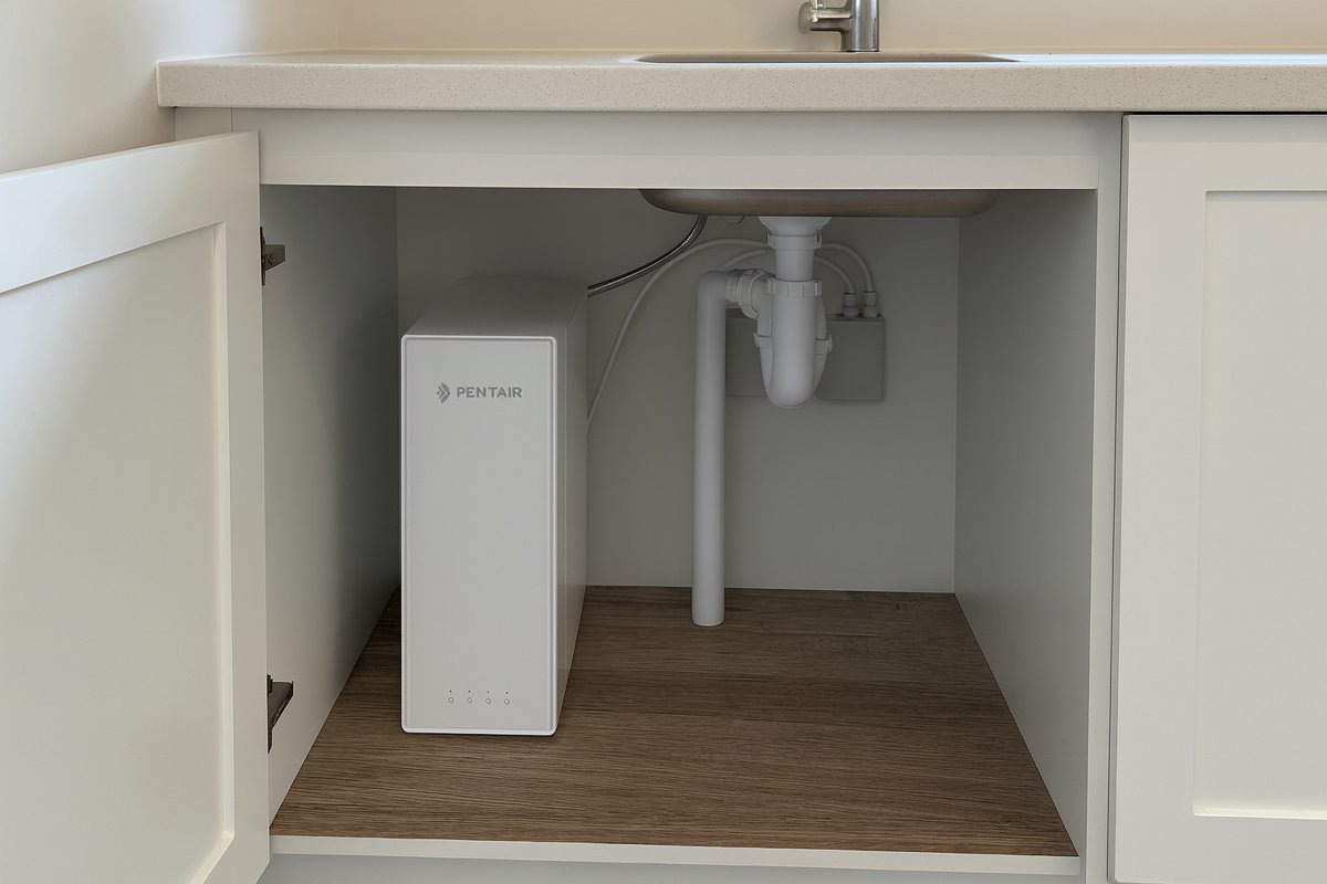 ES60 fitted under the sink in a white shaker kitchen